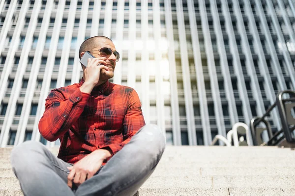 Mladý muž s mobilním telefonem ve městě. — Stock fotografie