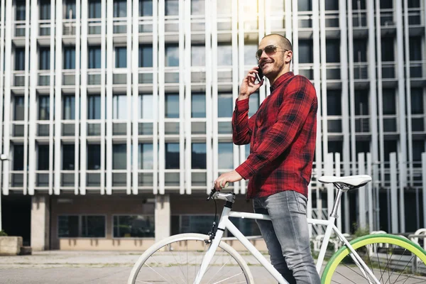 Giovane con cellulare e bicicletta a scatto fisso . — Foto Stock