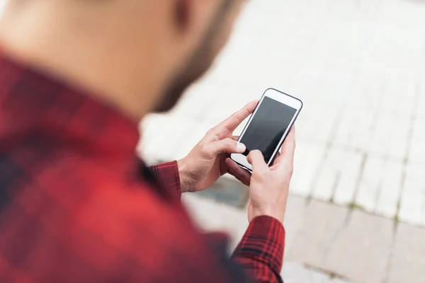 Young manusing his mobile in the street. — Stock Photo, Image