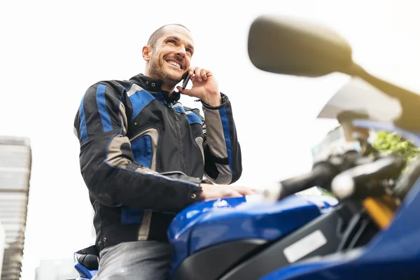 Schöner Biker mit Handy. — Stockfoto