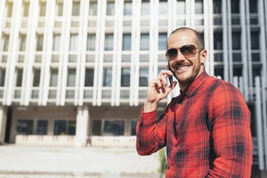 Şehirde cep telefonu olan genç bir adam..