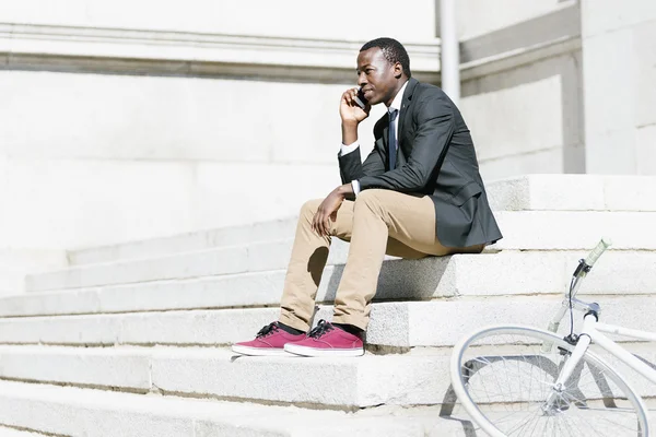 Homem africano com telefone celular e bicicleta . — Fotografia de Stock