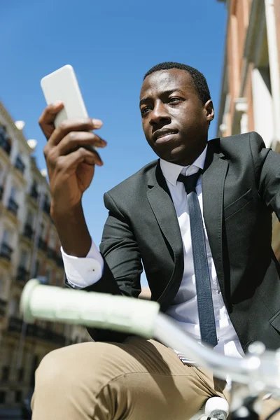 Handsome african man smiling when he is using his mobile. — Stock Photo, Image