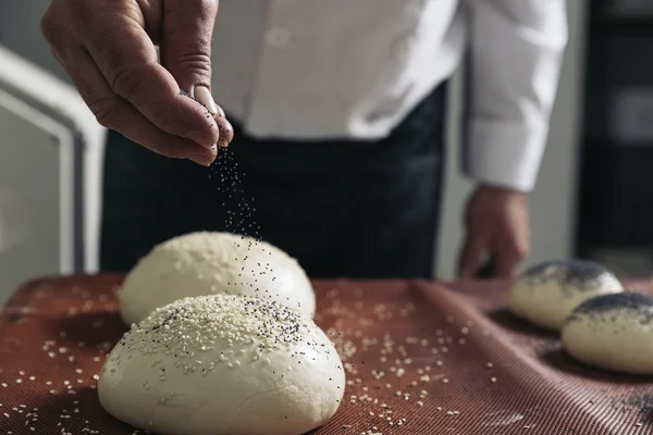 Baker amassar a massa de farinha em uma padaria. — Fotografia de Stock