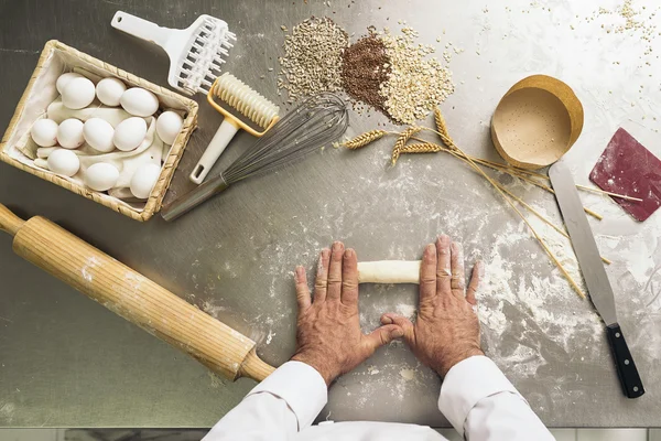 Baker kneden deeg in een bakkerij. — Stockfoto