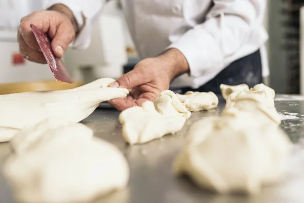 Panettiere impastare pasta in una panetteria. — Foto Stock