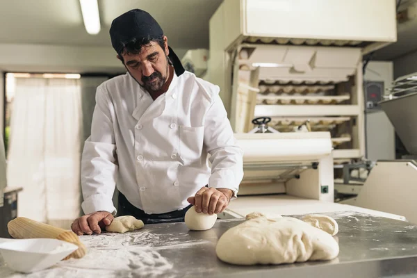 Panadero amasando masa en una panadería. —  Fotos de Stock