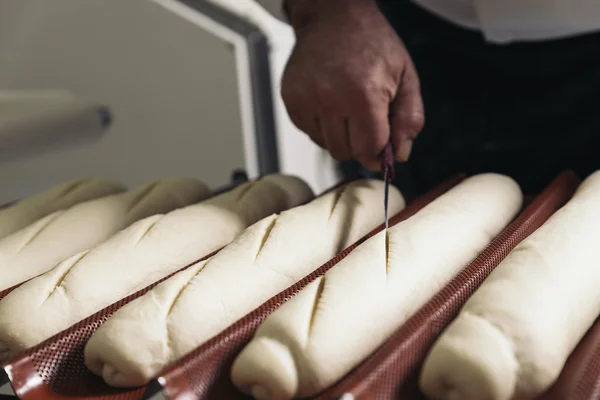 Baker amassar a massa de farinha em uma padaria. — Fotografia de Stock