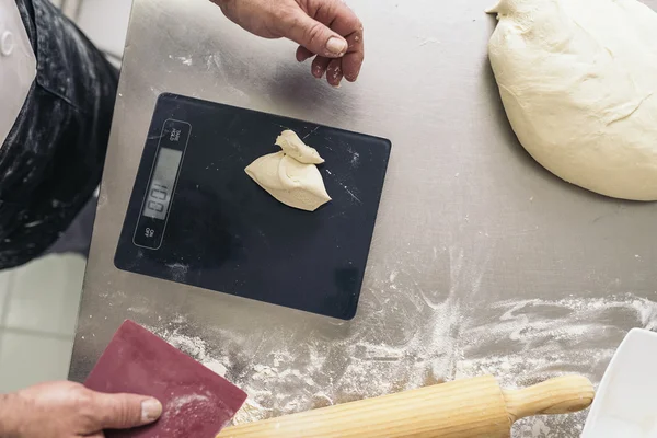 Bäcker knetet Teig in einer Bäckerei. — Stockfoto