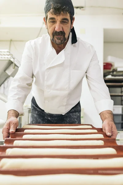 Panettiere impastare pasta in una panetteria. — Foto Stock