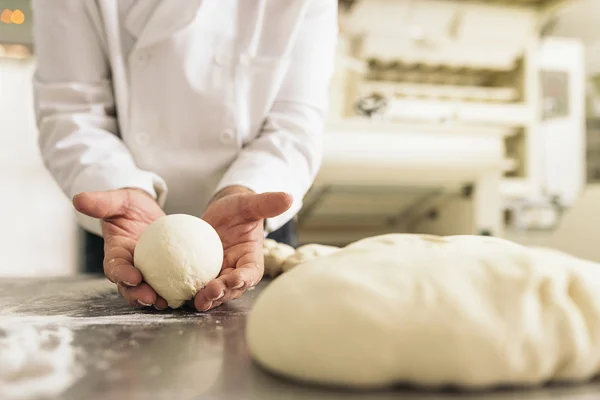 Baker gyúró tészta egy pékségben. — Stock Fotó
