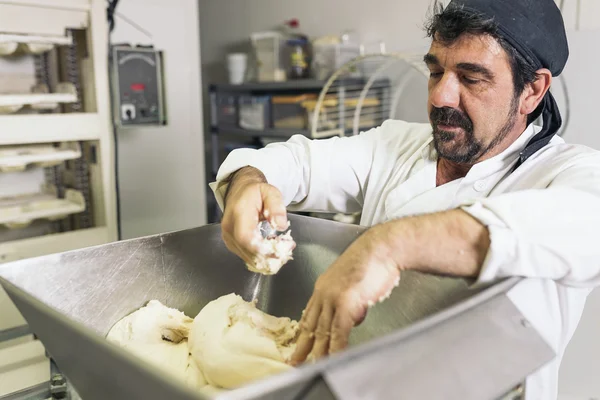 Panettiere impastare pasta in una panetteria. — Foto Stock