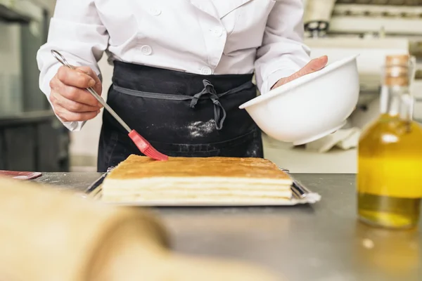 Kvinnliga konditor decorating dessert — Stockfoto