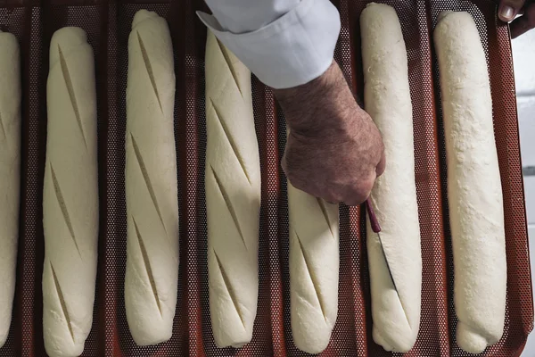Panadero amasando masa en una panadería. —  Fotos de Stock