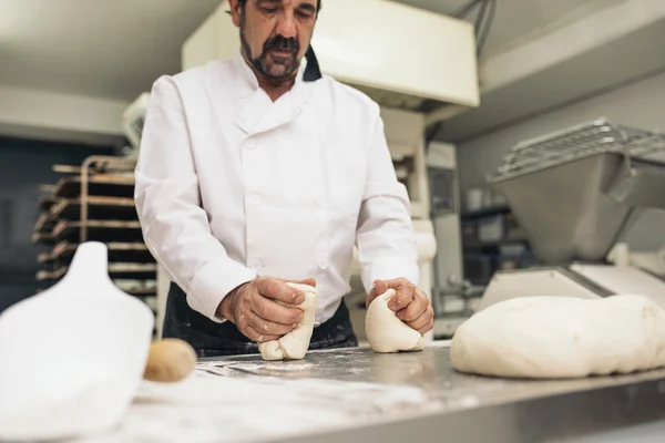 Bäcker knetet Teig in einer Bäckerei. — Stockfoto