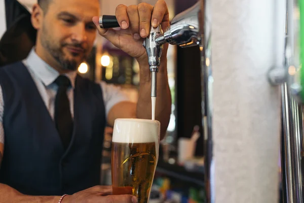 Barman servindo cerveja em um pub . — Fotografia de Stock