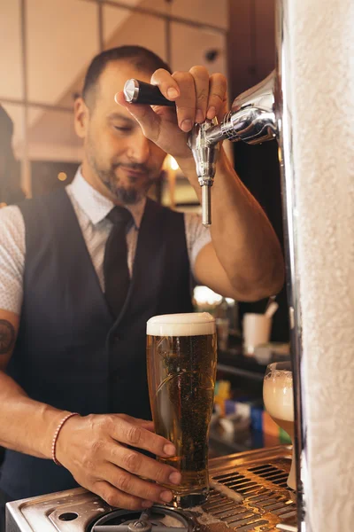 Cantinero sirviendo cerveza en un pub . —  Fotos de Stock