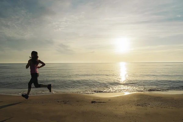 Mujer corriendo en la playa. — Foto de Stock