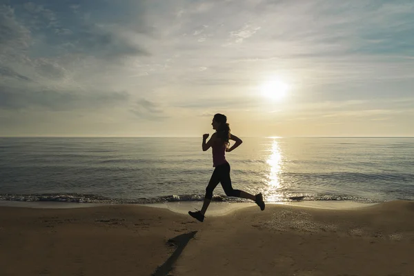 Mujer corriendo en la playa. — Foto de Stock