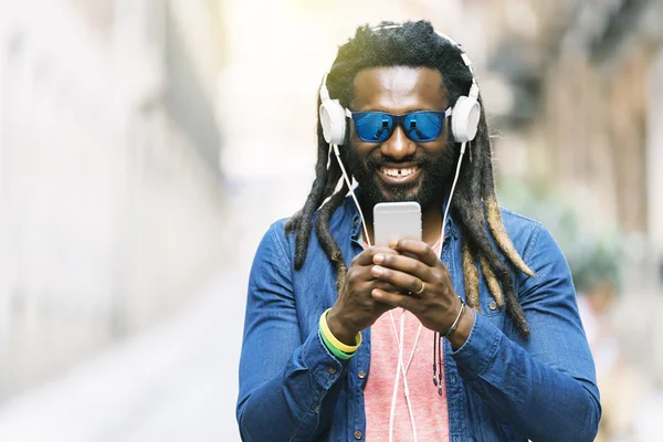 Jeune homme africain écoutant de la musique — Photo