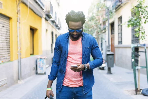 Jovem africano usando celular na rua . — Fotografia de Stock