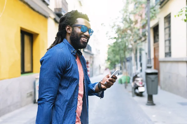 Afrikaanse jongeman met Mobile In de straat. — Stockfoto