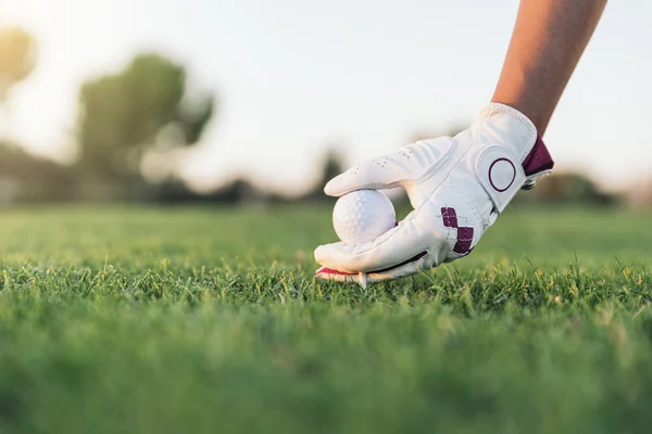 Wanita tangan menempatkan bola golf di tee . — Stok Foto
