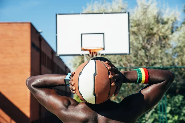Ανδρικό μπάσκετ παίκτης που κρατάει μια μπάλα. — Φωτογραφία Αρχείου