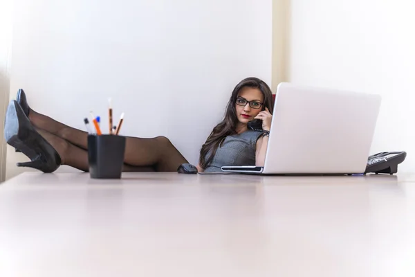 Relaxe mulher de negócios falando no telefone e usando seu laptop — Fotografia de Stock