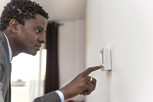 Africano americano homem apertar botão de controle de clima digital — Fotografia de Stock