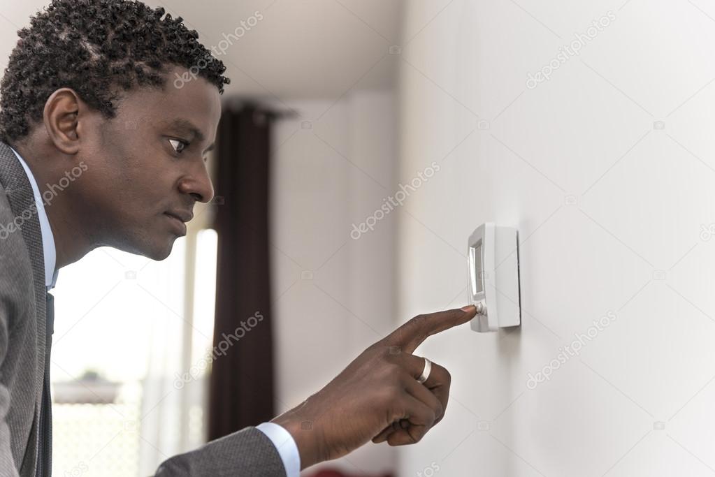 African american man push button digital climate control