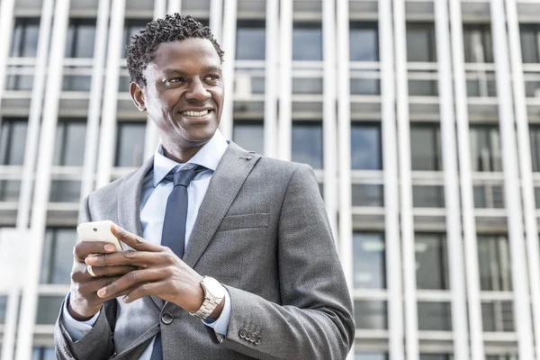 Bonito empresário afro-americano com telefone inteligente — Fotografia de Stock