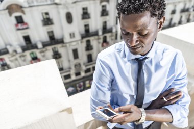 Balkon, smartphone ile Afrika iş adamı.