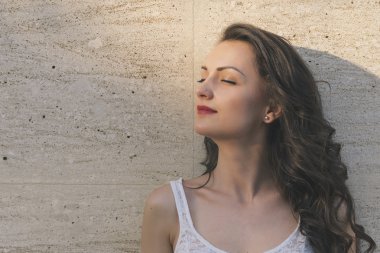 Çekici duvar arka plan karşı kadın ayakta gülüyor