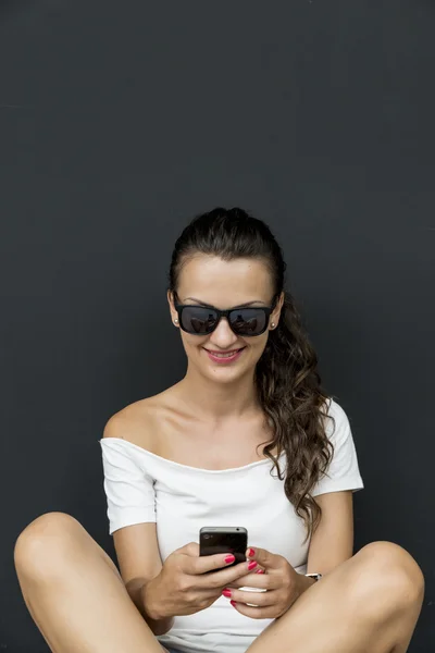 Schöne junge kaukasische Frau mit Smartphone, SMS. — Stockfoto