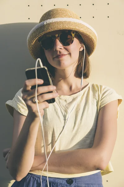 Beautiful young hipster Caucasian woman with smartphone and earp Royalty Free Stock Images