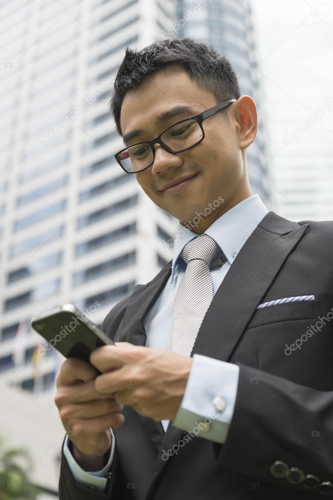 handsome business man writting email or message on phone
