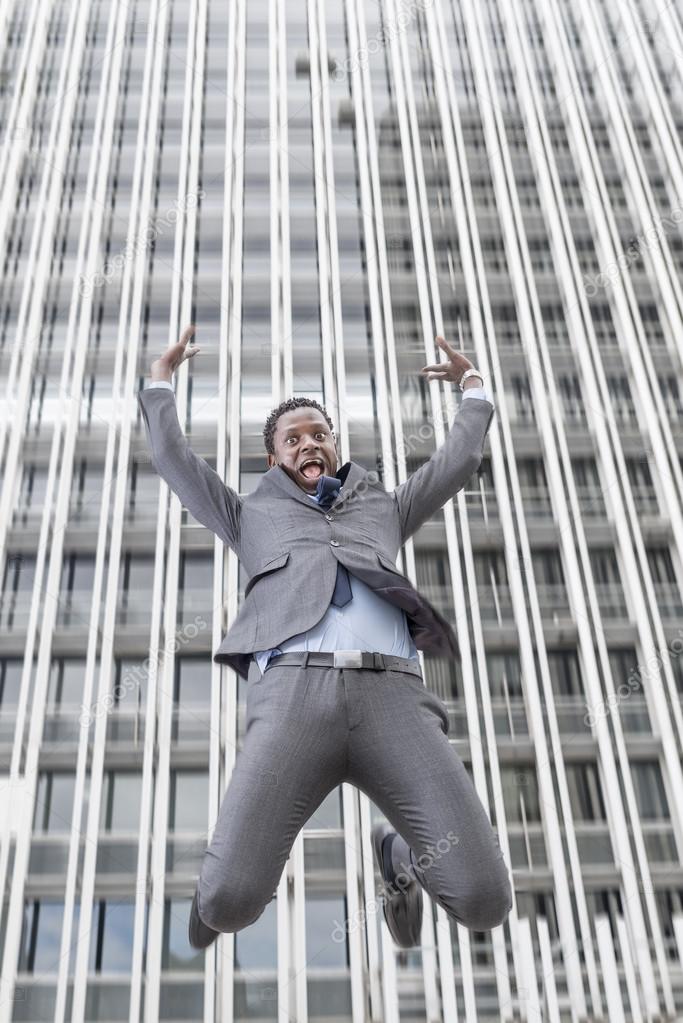 Businessman falling from a skyscraper over a city