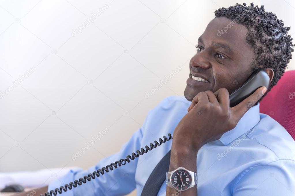 African American businessman on the phone sitting in his office