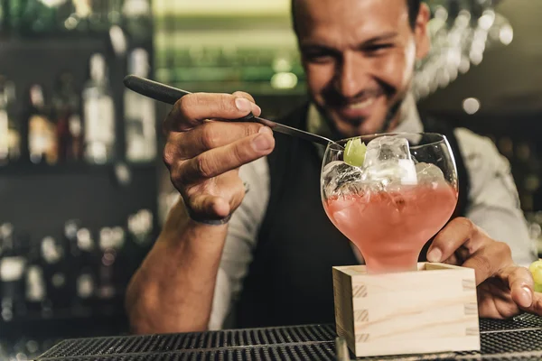 Barman is making cocktail at night club