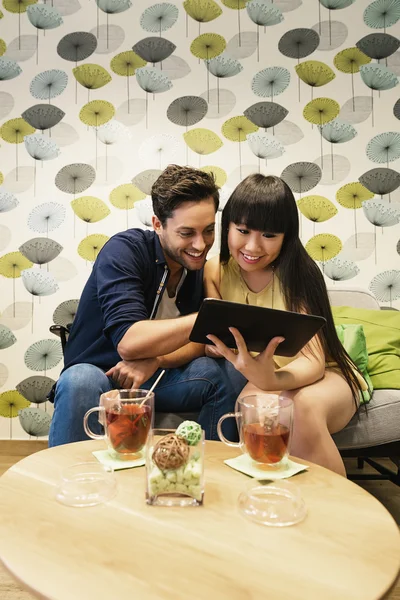 Casal feliz assistindo as mídias sociais em um caderno no bar . — Fotografia de Stock