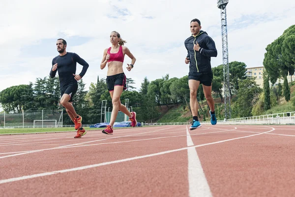 Gruppe junger Leute läuft auf dem Leichtathletikfeld — Stockfoto