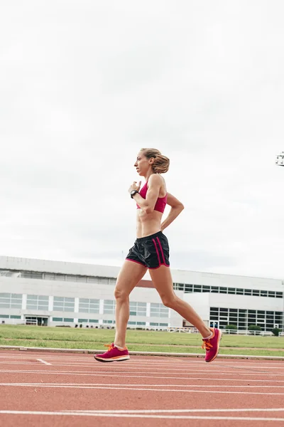 Atractiva mujer pista atleta corriendo en pista — Foto de Stock