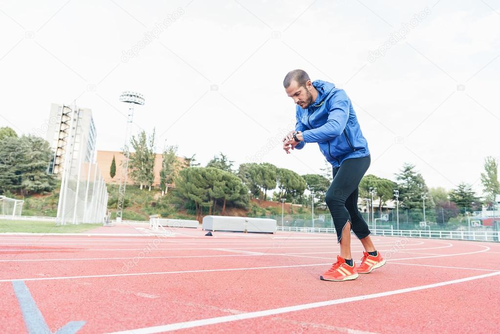 Runner ready to run is looking at his watch