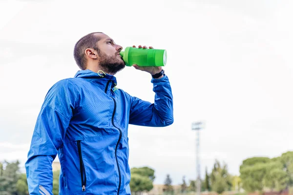 Bello corridore dopo aver corso a riposo e acqua potabile — Foto Stock