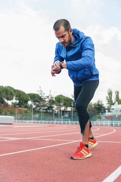 Laufbereiter Läufer schaut auf seine Uhr — Stockfoto