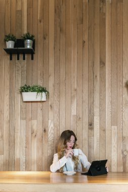 Şık iş kadını bir restoranda bir tablet ile çalışma