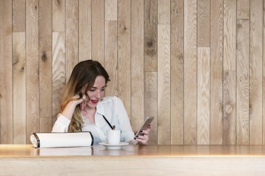 Şık iş kadını bir akıllı telefon ile bir restau yazý yazma
