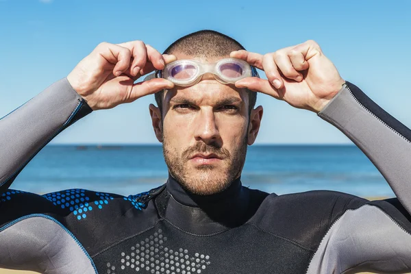 Handsome swimmer putting on goggles — Stock Photo, Image