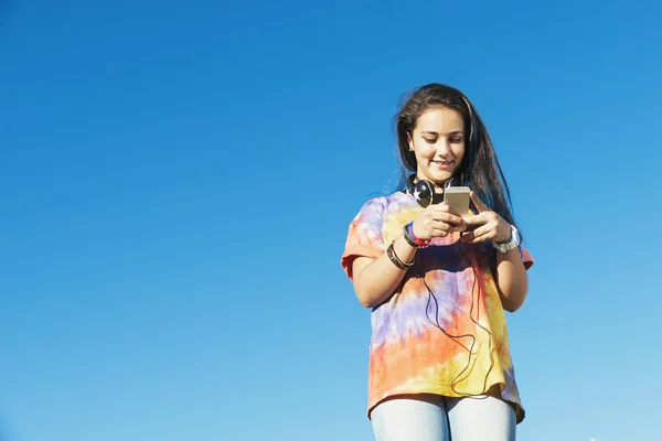 Szczęśliwy nastolatka przy użyciu komórkowego w parku — Zdjęcie stockowe